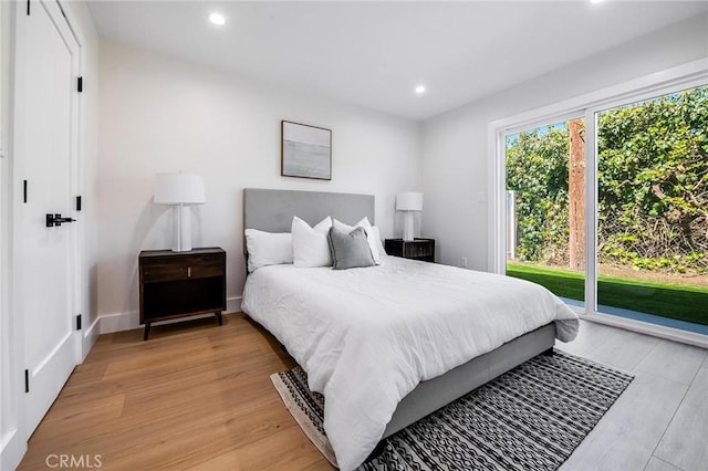 bedroom featuring baseboards, light wood-style floors, recessed lighting, and access to exterior