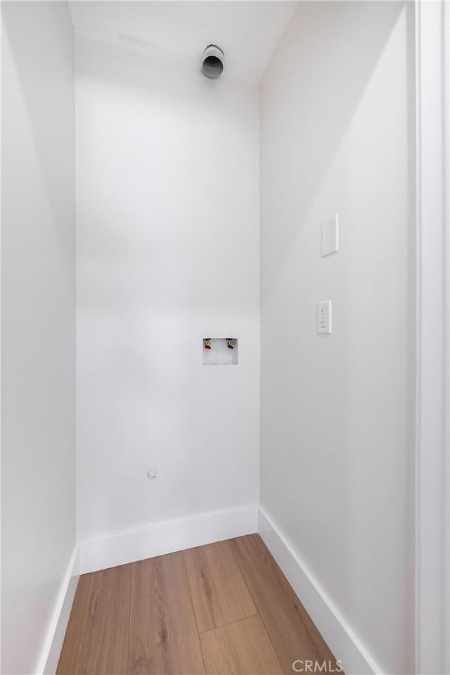 laundry room with hookup for a washing machine, laundry area, light wood-style flooring, and baseboards