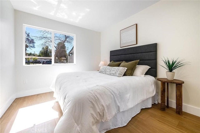 bedroom featuring baseboards and wood finished floors