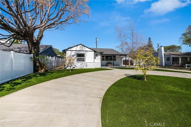 view of front of house with fence, a front lawn, concrete driveway, and brick siding