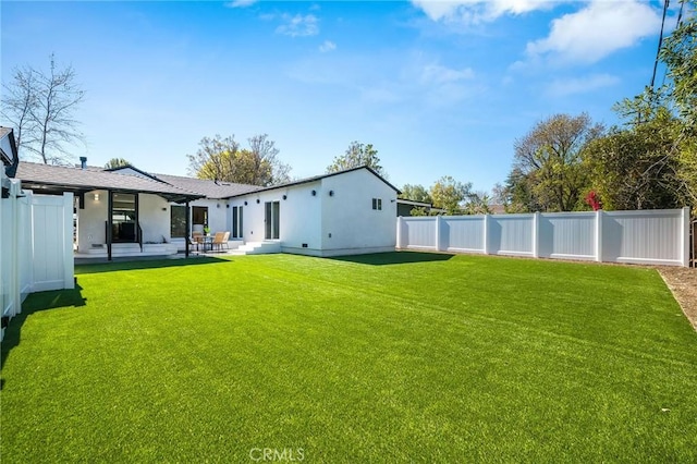 back of house featuring a patio, a lawn, and a fenced backyard