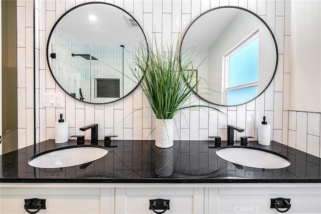 bathroom with vanity, decorative backsplash, and walk in shower