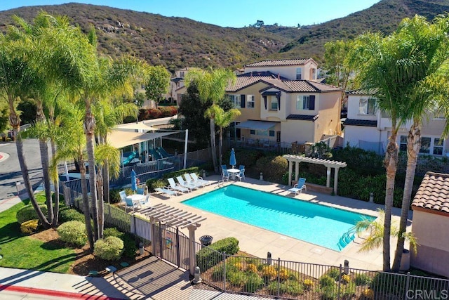 pool featuring a mountain view, a patio area, fence, and a pergola