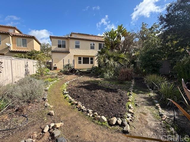 back of property with fence and stucco siding