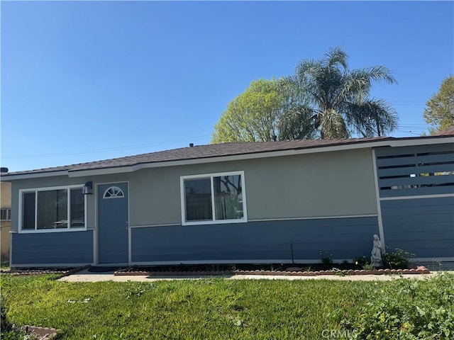 single story home featuring a front lawn