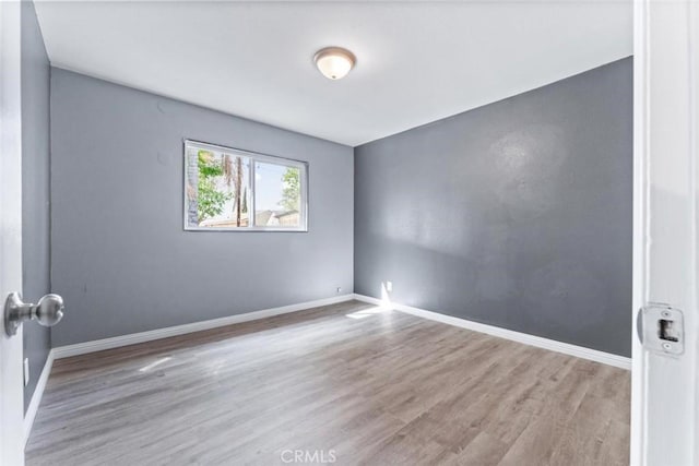 empty room featuring baseboards and wood finished floors