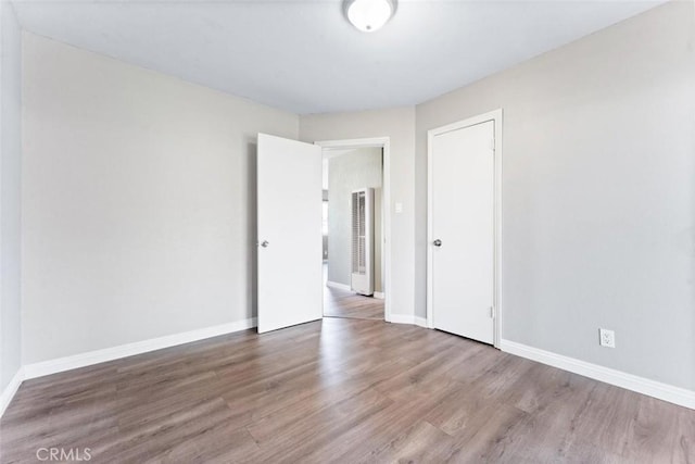 unfurnished room featuring baseboards and wood finished floors