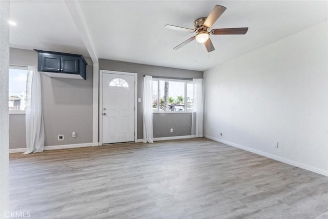 entrance foyer featuring baseboards, a ceiling fan, and light wood-style floors