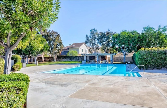 community pool with a patio area and a pergola