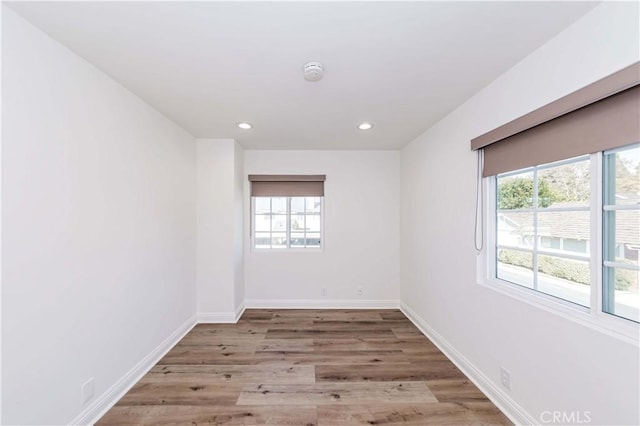 unfurnished room featuring recessed lighting, baseboards, and wood finished floors