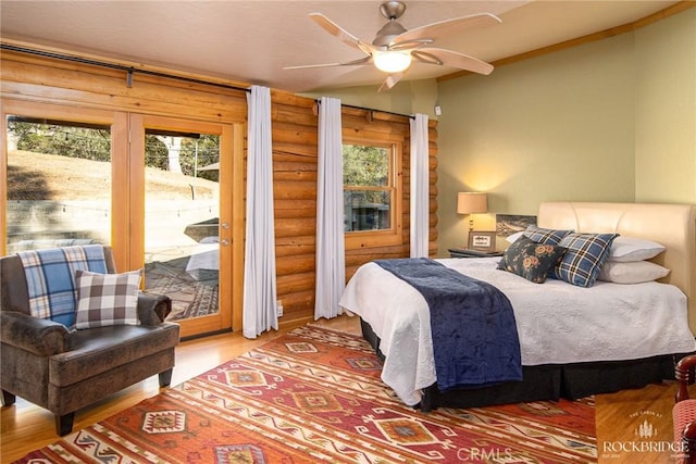 bedroom featuring access to exterior, multiple windows, and wood finished floors