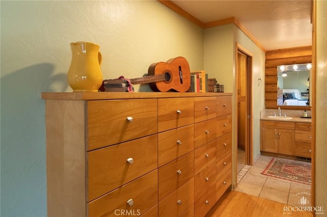 interior space with a sink, log walls, and light tile patterned floors