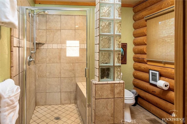 bathroom featuring toilet, a shower stall, and log walls