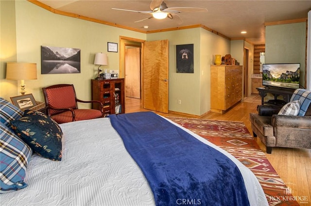 bedroom with baseboards, ceiling fan, ornamental molding, and wood finished floors