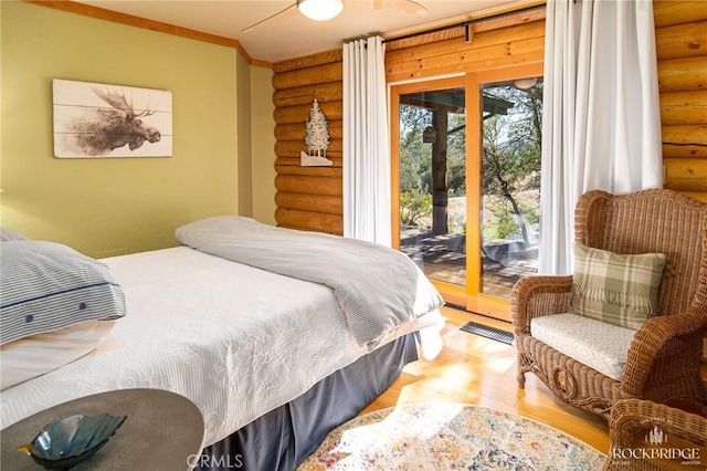 bedroom with access to outside, visible vents, wood finished floors, and ornamental molding