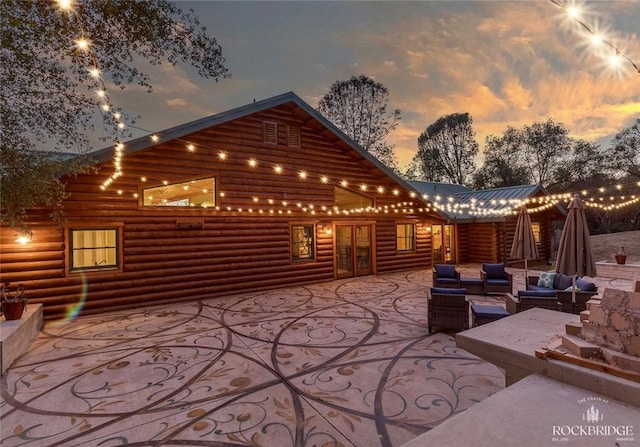 patio terrace at dusk featuring french doors and an outdoor living space