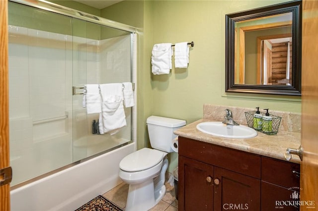 full bathroom featuring tile patterned flooring, enclosed tub / shower combo, vanity, and toilet