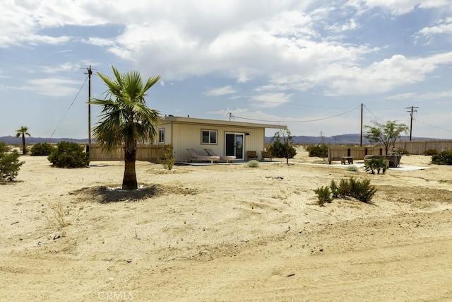 rear view of house featuring fence