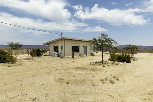 back of property featuring fence and a mountain view