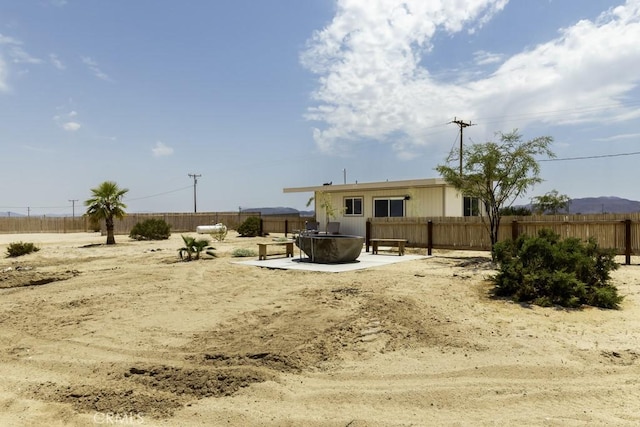 rear view of house with a patio area, fence, and a fire pit