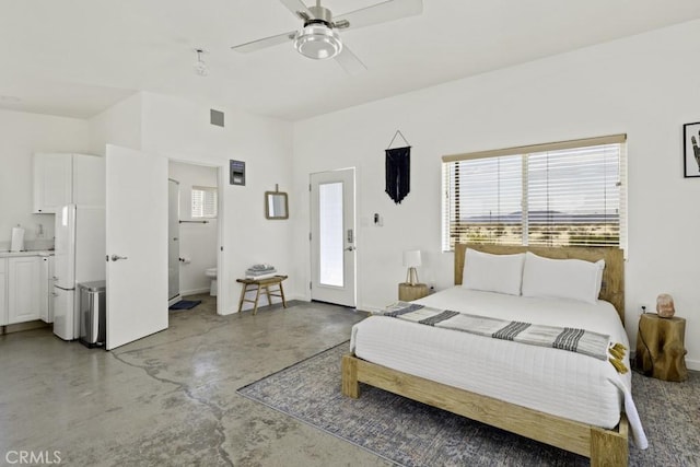 bedroom featuring visible vents, ensuite bath, ceiling fan, freestanding refrigerator, and concrete floors