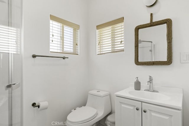 full bathroom with toilet, vanity, and a shower with shower door