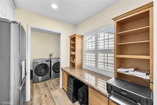 washroom with laundry area, washing machine and dryer, and light wood finished floors