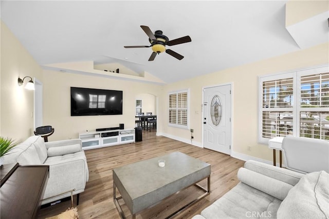 living room with baseboards, arched walkways, a ceiling fan, lofted ceiling, and wood finished floors