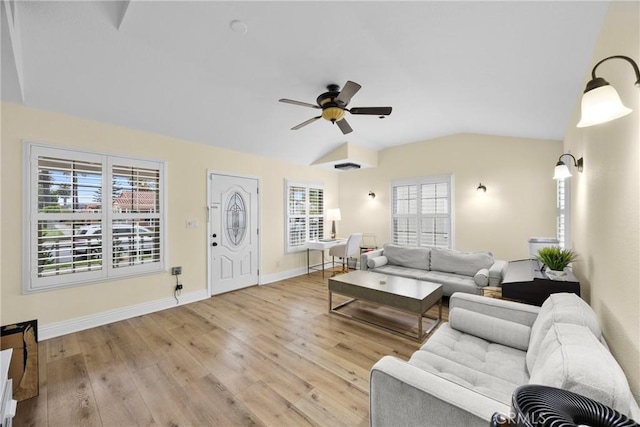 living room featuring lofted ceiling, plenty of natural light, wood finished floors, and baseboards