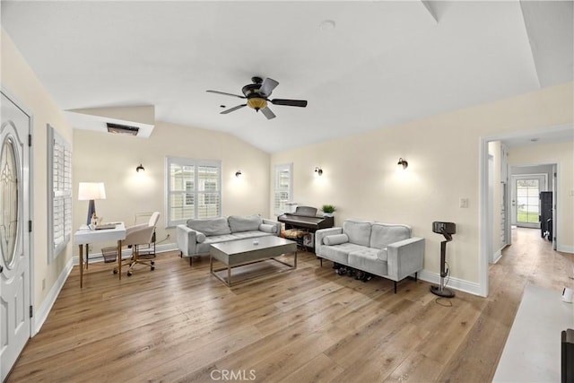 living area featuring light wood-style floors, a ceiling fan, vaulted ceiling, and a wealth of natural light