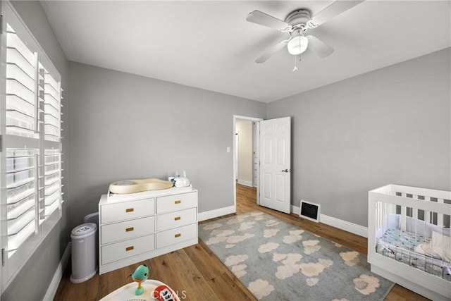 bedroom featuring baseboards, visible vents, and wood finished floors