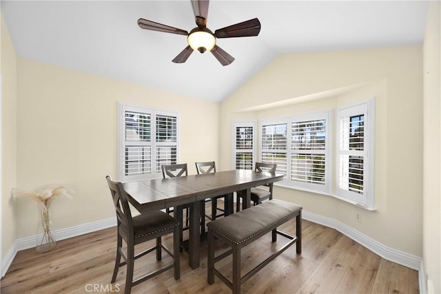 dining room with baseboards, vaulted ceiling, light wood finished floors, and ceiling fan