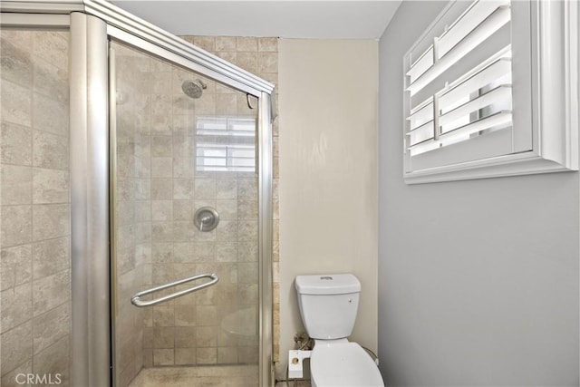 bathroom featuring a shower stall and toilet