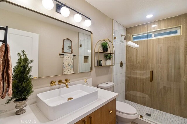 full bathroom with a stall shower, vanity, and toilet