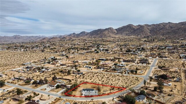 drone / aerial view featuring a mountain view and view of desert