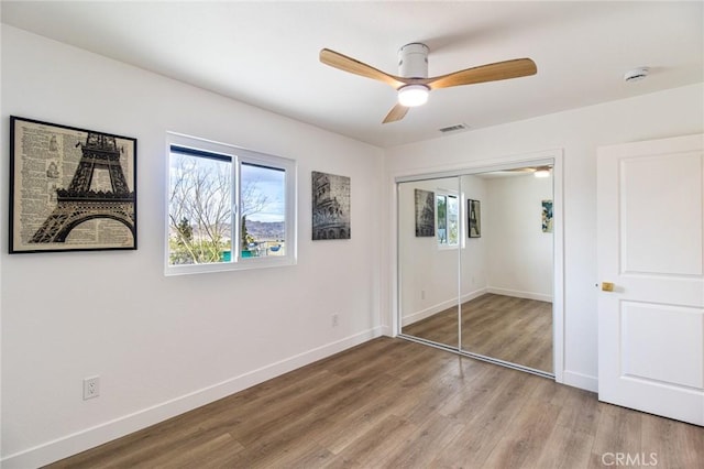 unfurnished bedroom featuring light wood-style flooring, a closet, visible vents, and baseboards