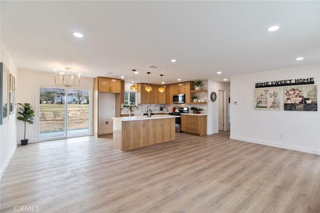 kitchen featuring appliances with stainless steel finishes, open floor plan, light countertops, and open shelves