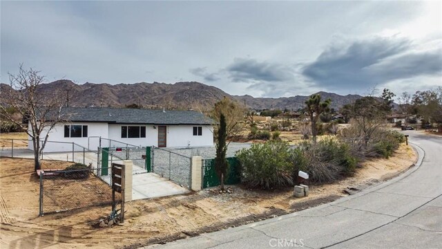 exterior space featuring a gate, a mountain view, and fence