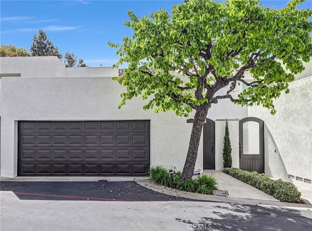 exterior space with a garage and stucco siding