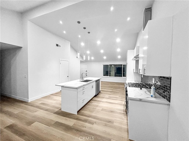 kitchen with a center island with sink, white cabinetry, stainless steel appliances, and a sink