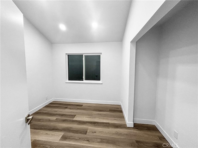 empty room featuring recessed lighting, wood finished floors, and baseboards