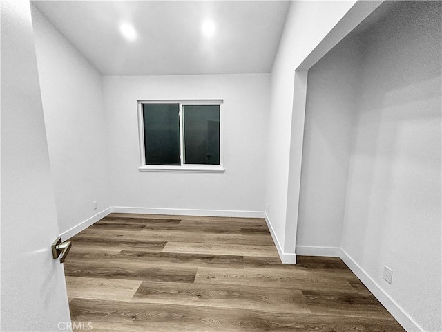 empty room with wood finished floors and baseboards