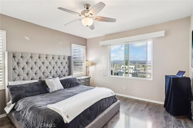 bedroom featuring a ceiling fan, wood finished floors, and baseboards