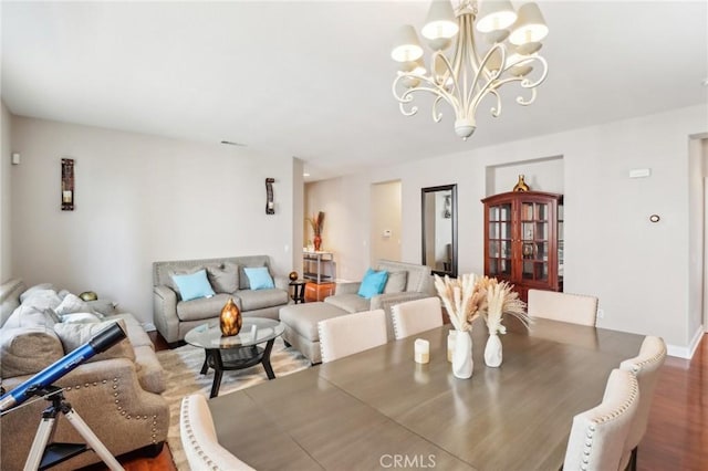 dining area with wood finished floors, visible vents, and a chandelier