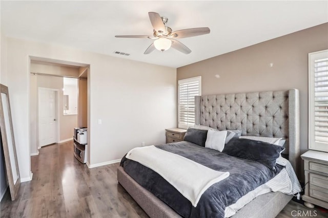 bedroom with ceiling fan, wood finished floors, visible vents, and baseboards