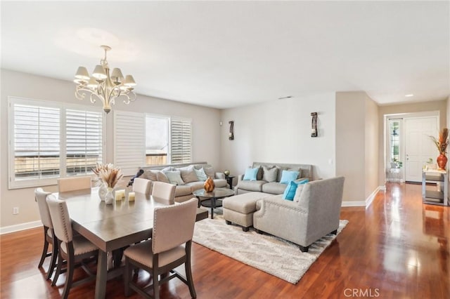 dining room with wood finished floors, a notable chandelier, a healthy amount of sunlight, and baseboards