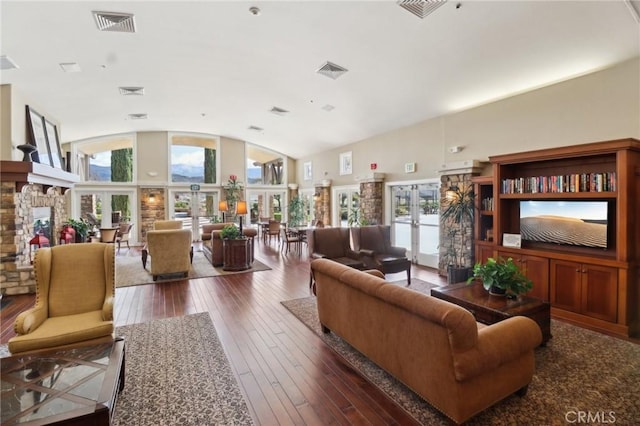 living area featuring french doors, wood-type flooring, visible vents, and vaulted ceiling