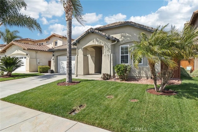 mediterranean / spanish-style home featuring a front lawn, an attached garage, driveway, and stucco siding