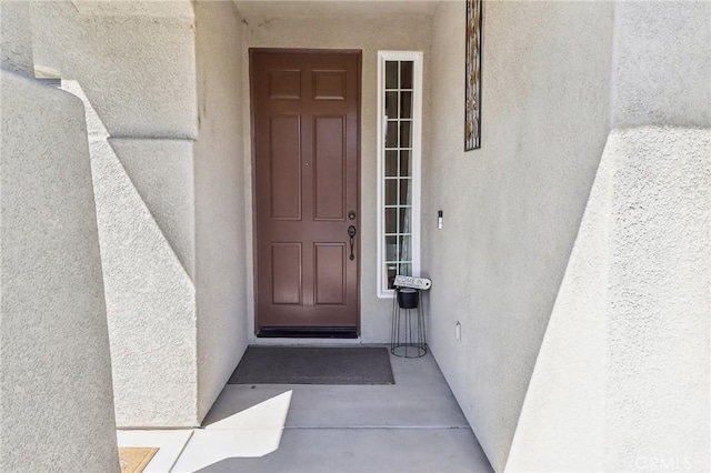 view of exterior entry with stucco siding