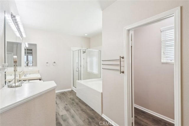 full bath with a shower stall, baseboards, a garden tub, and wood finished floors